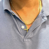 A close-up view of a person wearing a 24K gold-plated cross pendant necklace on a 14K gold-plated Figaro chain, styled over a light blue collared shirt